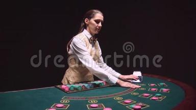 扑克游戏经销商在绿色的桌子上分发卡片。 黑色背景。 慢动作